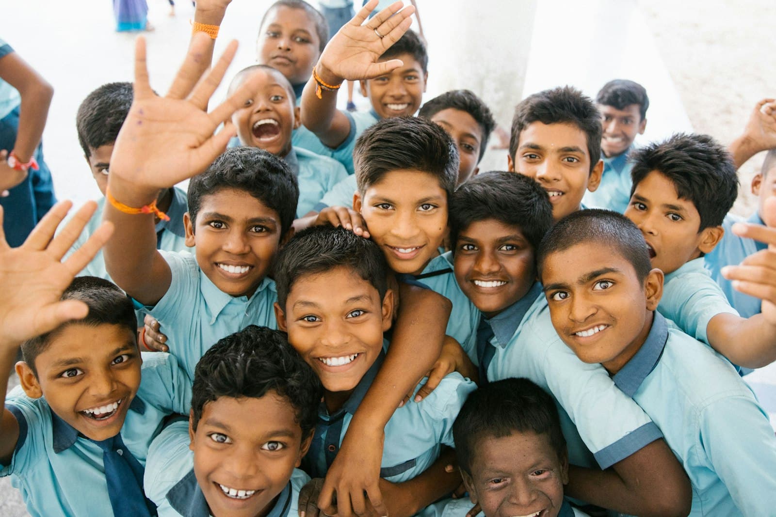 Smiling school children waving at the camera